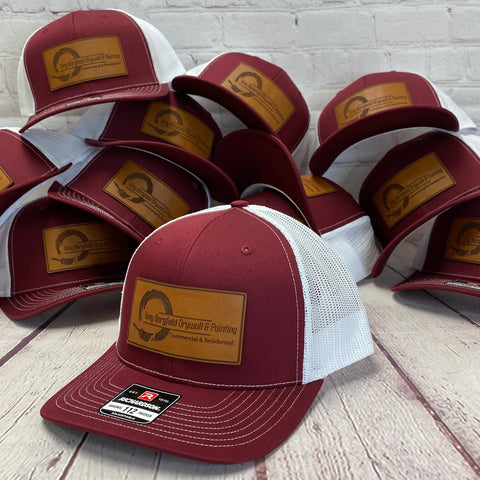 Richardson 112 trucker hat maroon color with white mesh backing featuring a custom leather patch with 