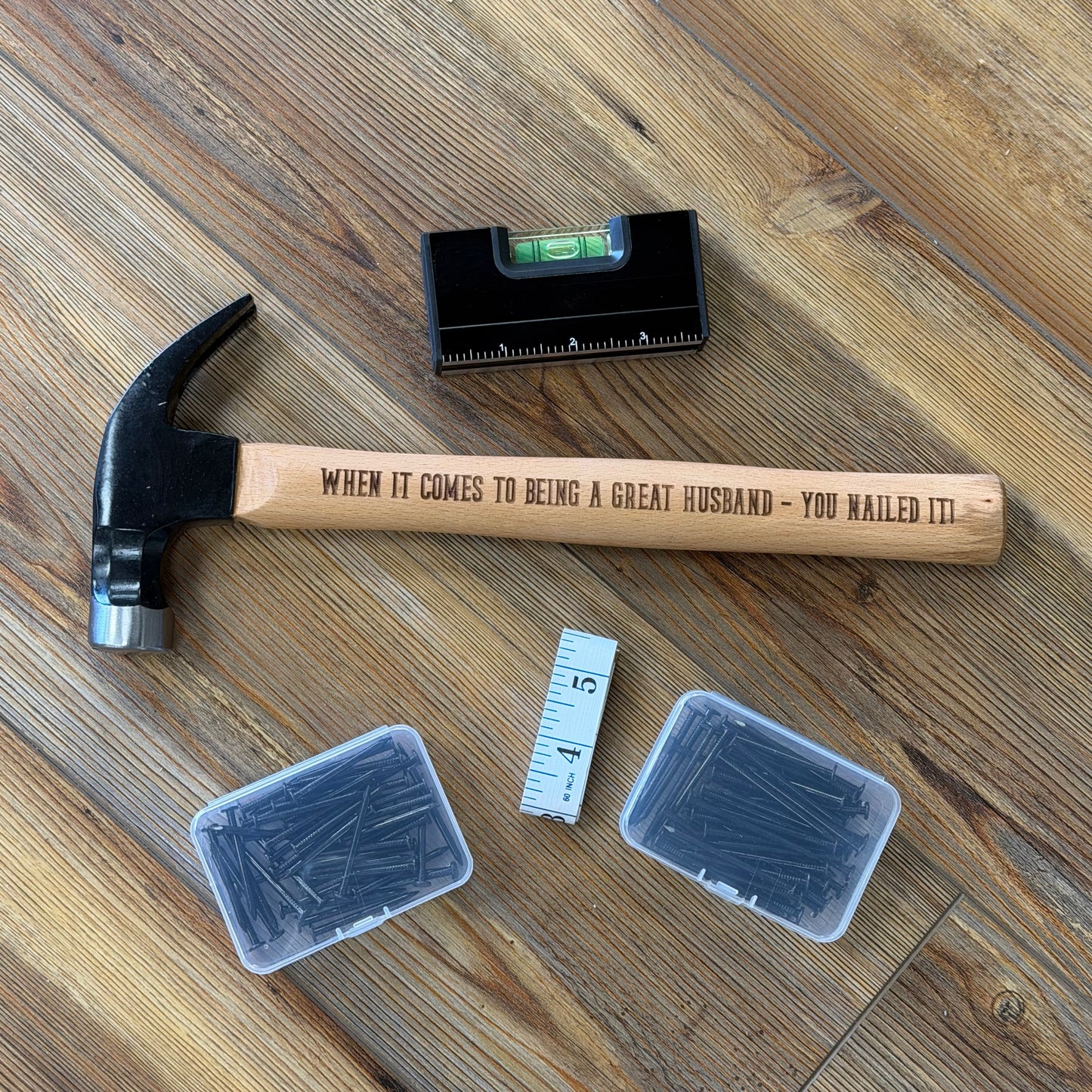 Hammer, level, and plastic containers on a wooden floor