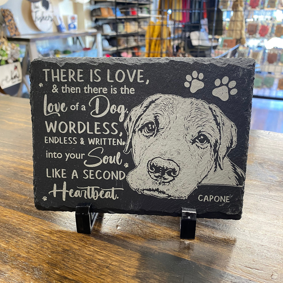 Decorative sign with a dog illustration and text on a wooden surface.
