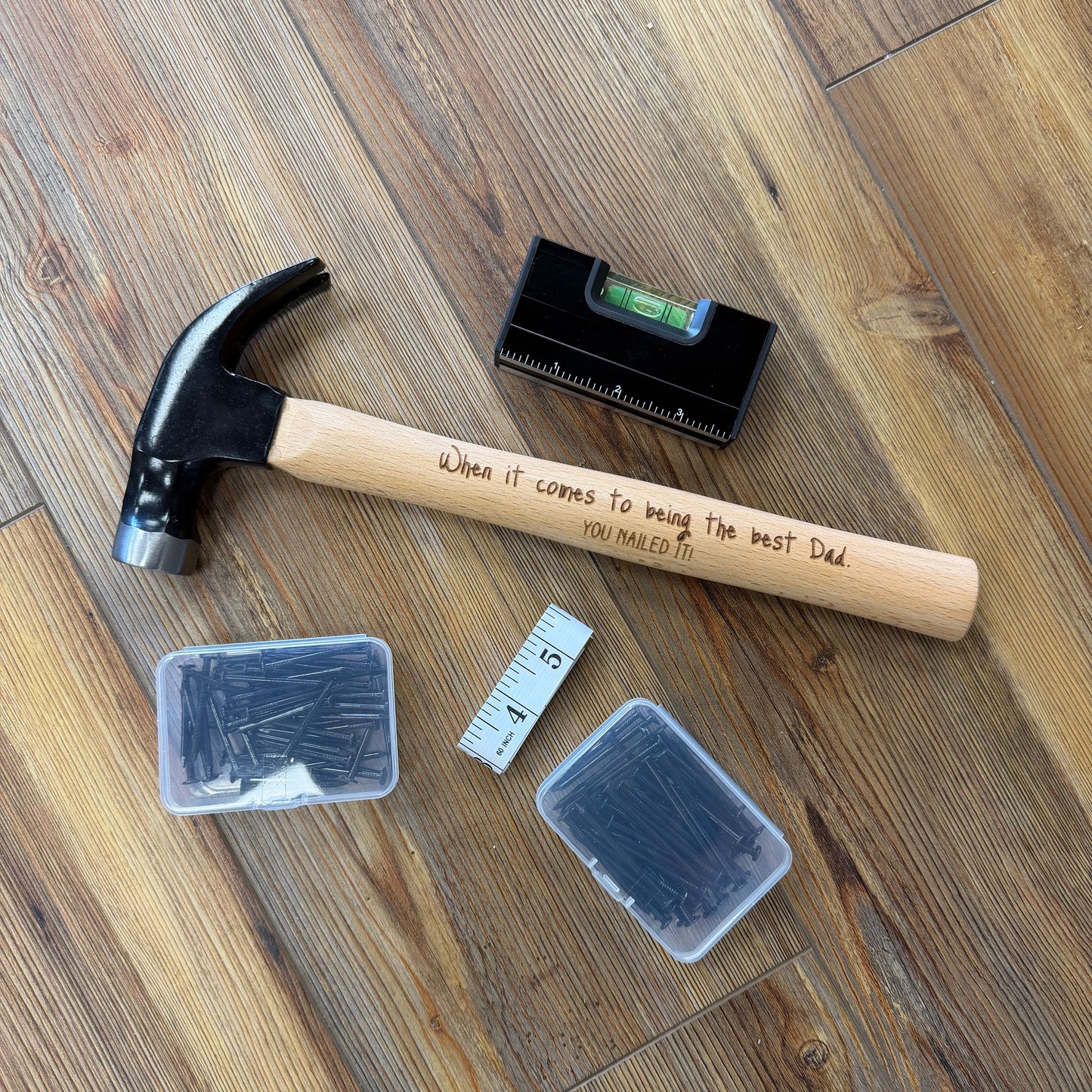 Hammer, level, and small containers on a wooden floor