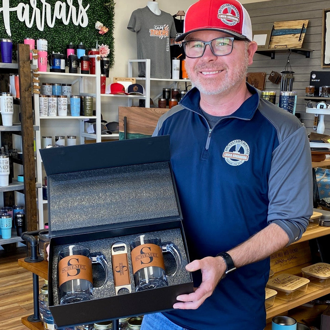 Man holding a gift set with branded items in a store setting