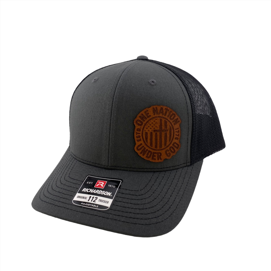 A black and gray 'One Nation Under God' Richardson 112 trucker hat with a leather patch on the front.