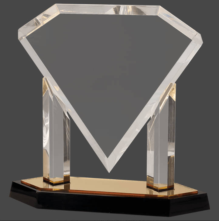 An acrylic award in the shape of a diamond with a reflective surface, featuring a personalized engraving plaque on a mirror base, primarily in gold color.