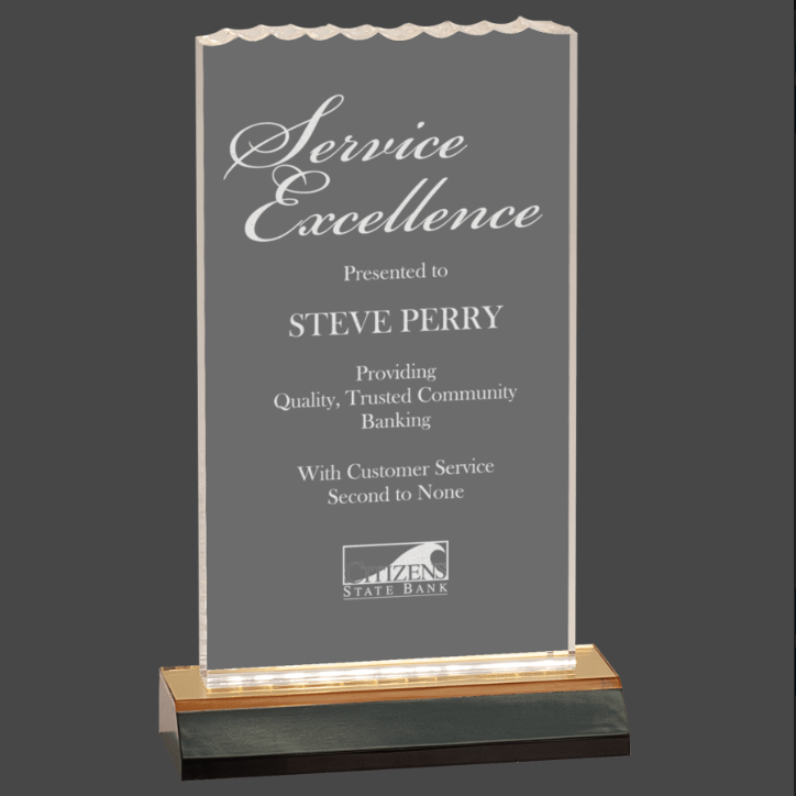 An acrylic clear award , featuring a gold base, and engraved text with a congratulatory message.