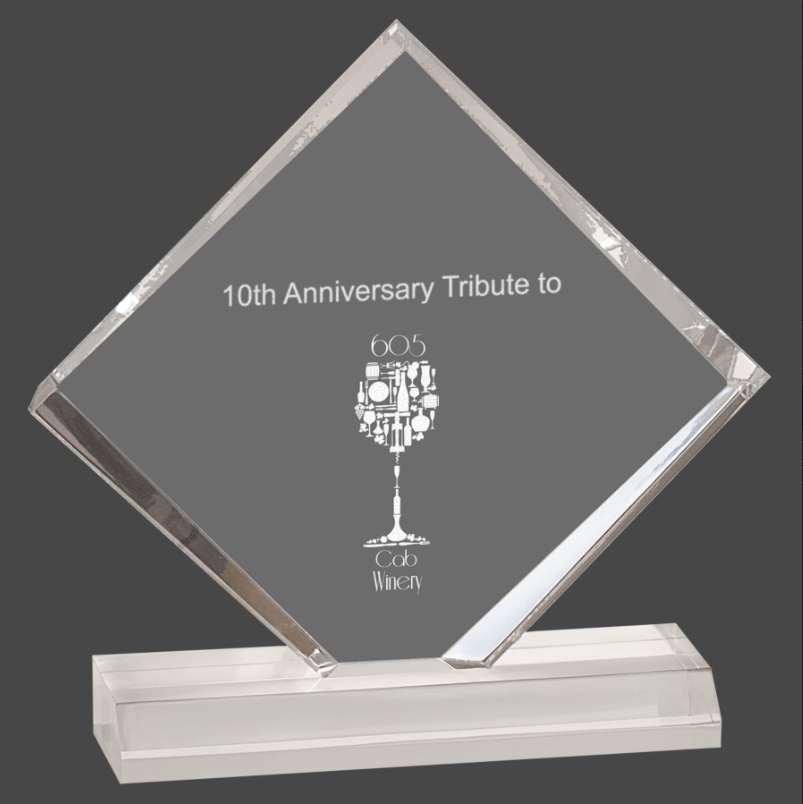 A clear acrylic award with a beveled edge, featuring a personalized engraving plaque that reads '10th Anniversary Tribute' and includes a wine glass graphic.