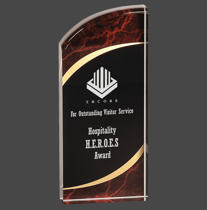 An acrylic award with a red marble-like background and gold text that reads 'For Outstanding Visitor Service' with a logo at the top.