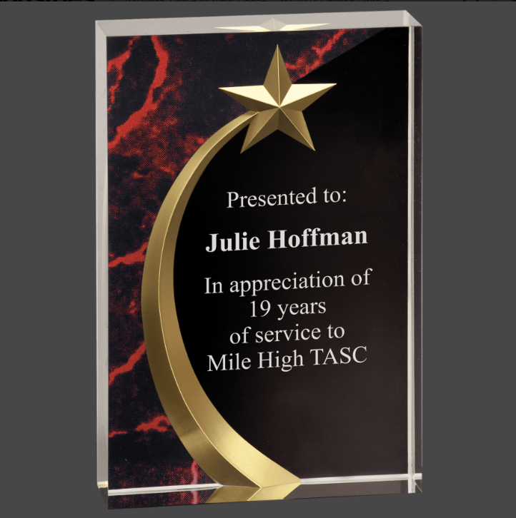 An acrylic award with a shooting star and starburst design, featuring a black textual plaque 