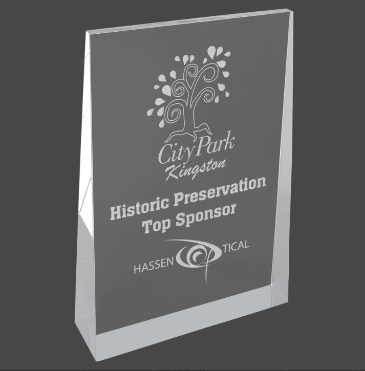 A silver acrylic wedge award with custom laser engraving text and logo.