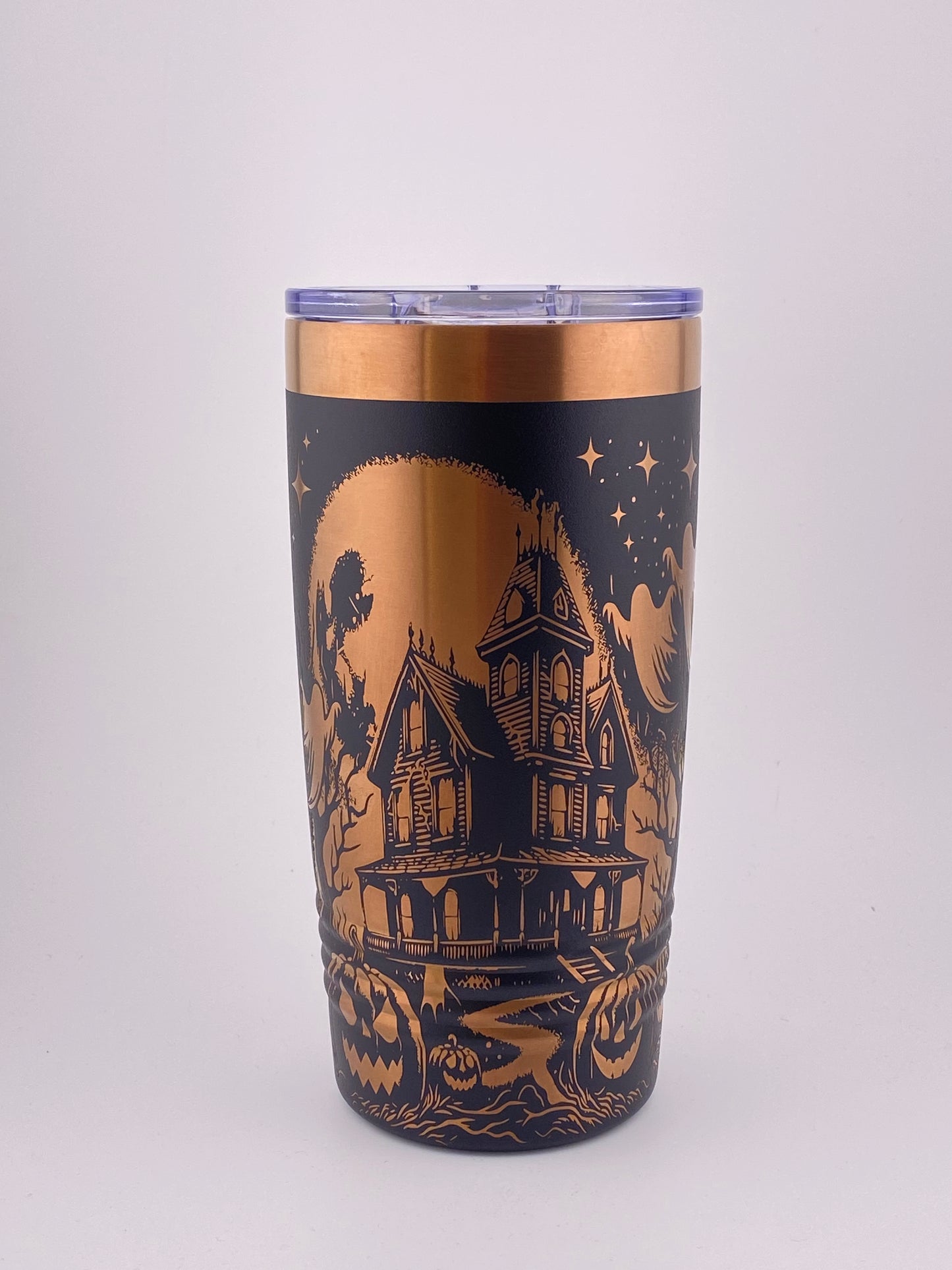 A 20oz stainless steel polar camel tumbler with a black and rose gold color scheme, featuring a haunted house and moon and stars pattern.